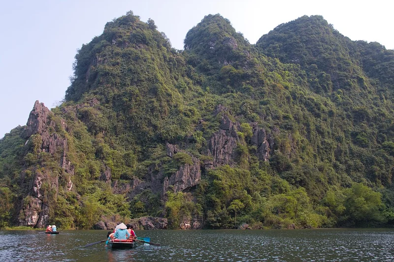 Thuyền nhỏ giữa dòng nước và núi đá Tràng An